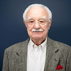 Bob Kazimour smiles into the camera against a dark blue background.
